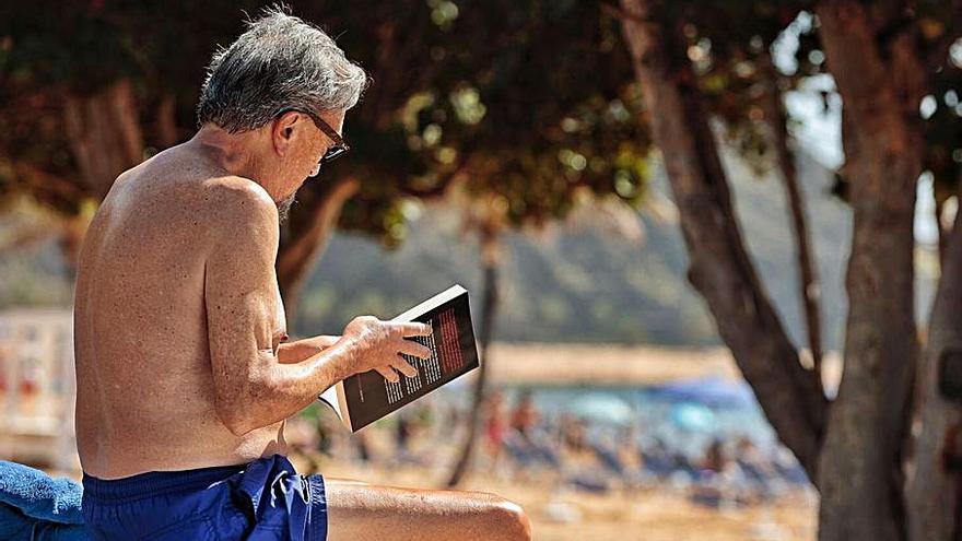 Un hombre disfruta de su libro en la playa de Las Teresitas.