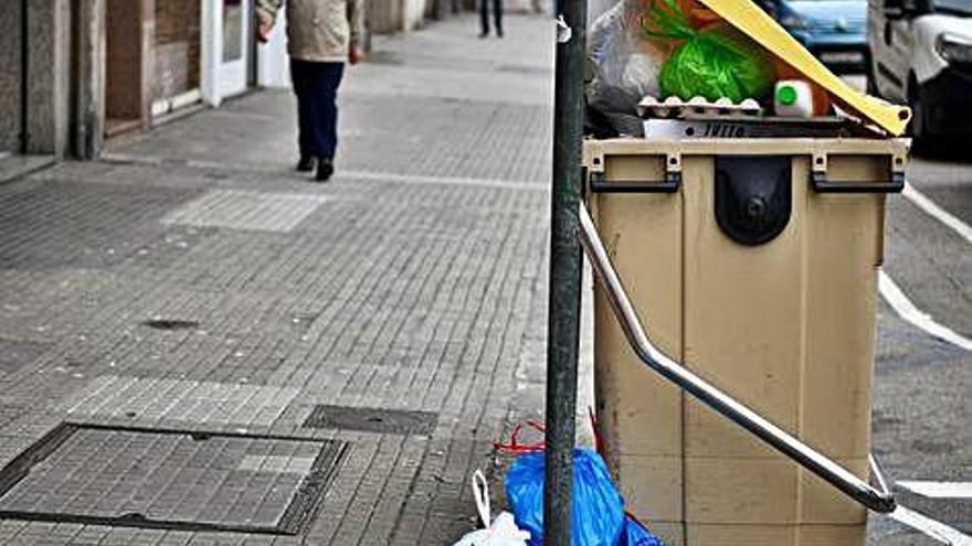 Uno de los contenedores con basura sin recoger, ayer.