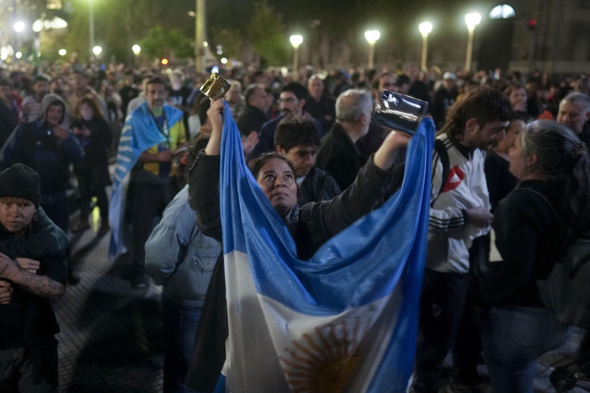 A person bangs a saucepan in front the government house as she protests the government's repression of Wednesday's demonstrations in Buenos Aires, Argentina, Thursday, March 13, 2025. (AP Photo/Natacha Pisarenko)