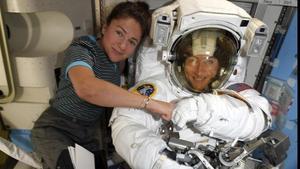 Christina Koch, a la derecha, y Jessica Meir, con traje de astronauta, en la estación espacial internacional.