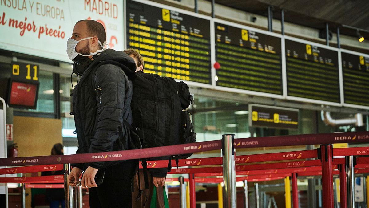 Un pasajero mira los vuelos de salida en un panel de algún aeropuerto isleño