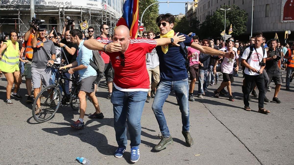 Un asistente a la manifestación de la Policía es agredido por un independentista, este sábado en Barcelona.