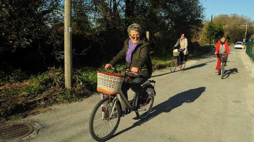 Tres mujeres pasean en bicicleta por A Illa, ayer a primera hora de la mañana. // Iñaki Abella