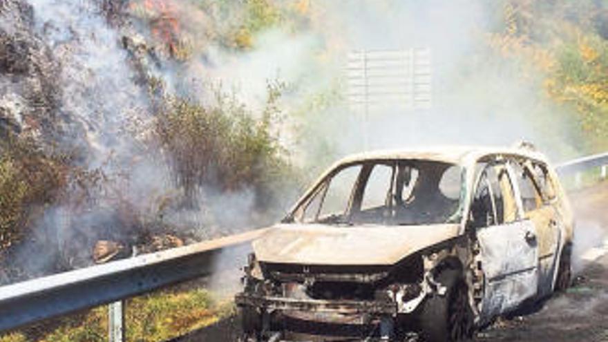 El coche quedó calcinado y las llamas se propagaron al monte próximo a la A-52. // FdV