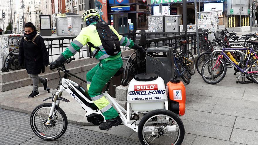 Personal del servicio de limpieza del Ayuntamiento de Madrid trabaja en una calle.