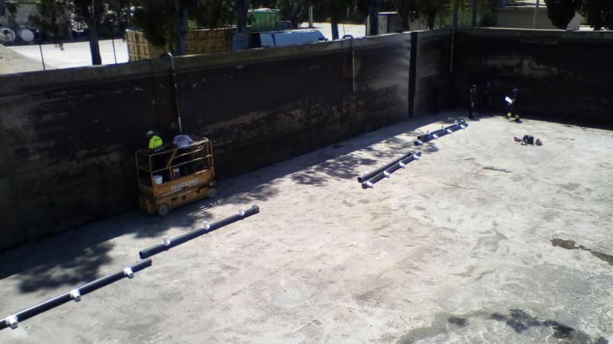 Operarios trabajando en la reparación de una de las grandes balsas de agua de la depuradora.