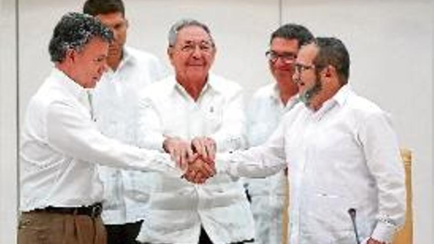 Santos i el líder de les FARC (amb barba) encaixen les mans.