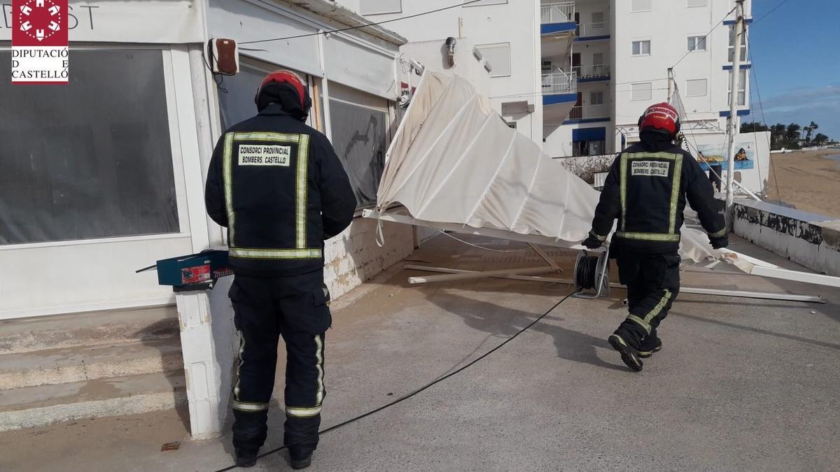 Los bomberos retiran un toldo caído por el viento en Benicarló.