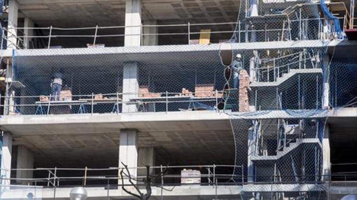 Obreros en un edificio cuya construcción había estado parada.