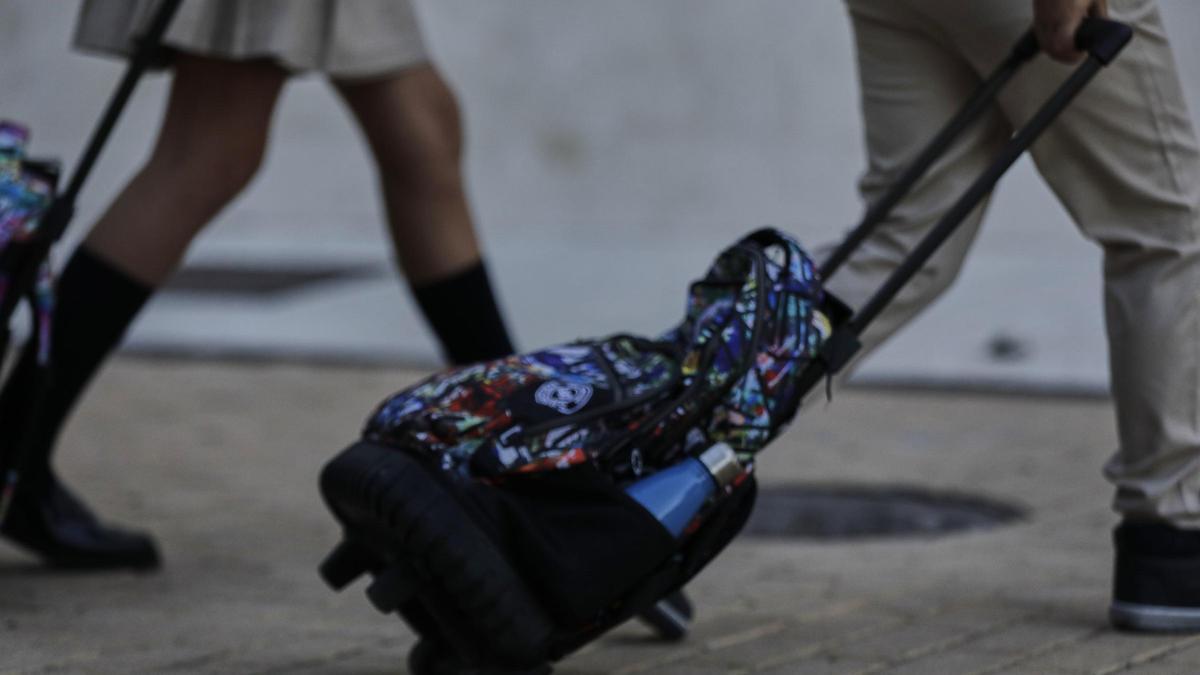 Alumnos de camino al colegio con sus mochilas.