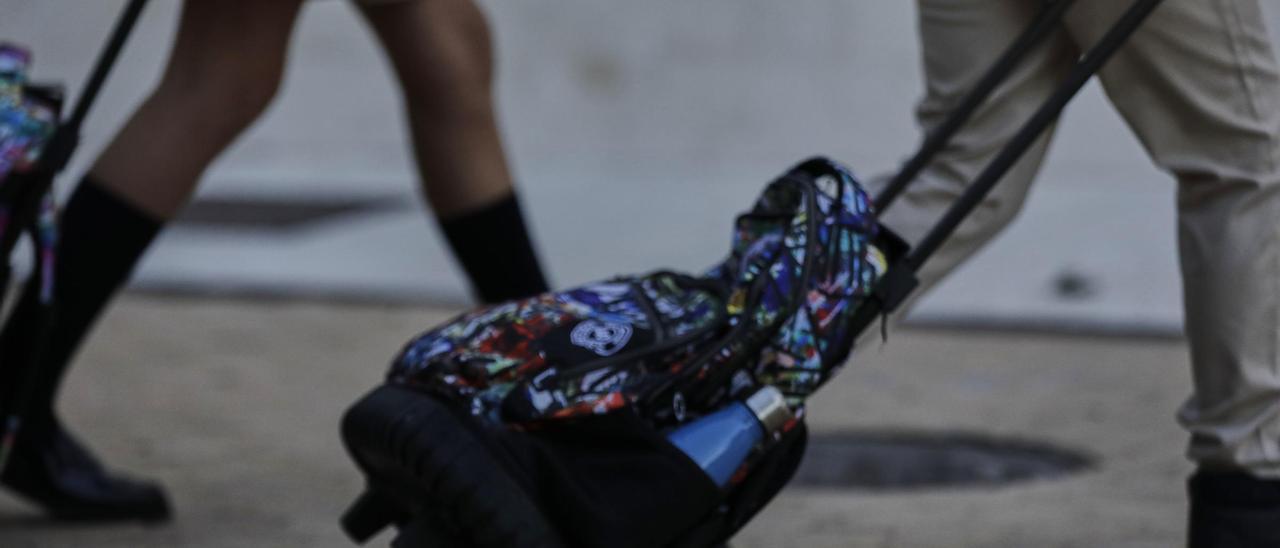 Alumnos de camino al colegio con sus mochilas.