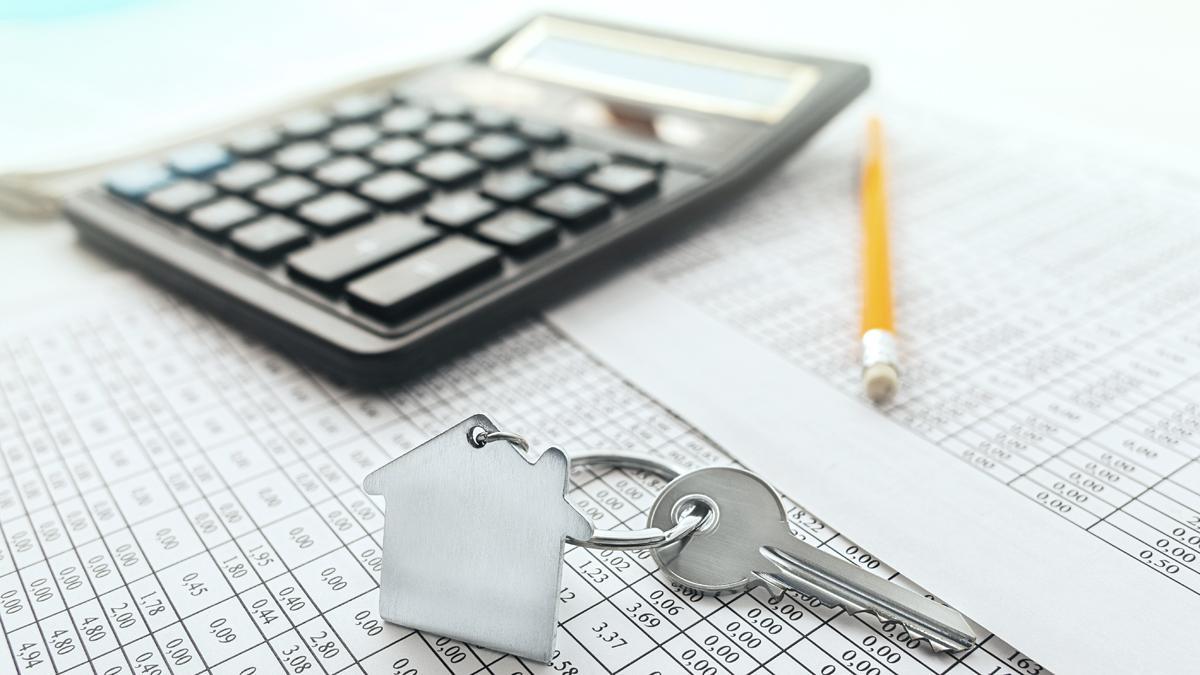 Una llave de una casa, junto a una calculadora. Tema hipoteca