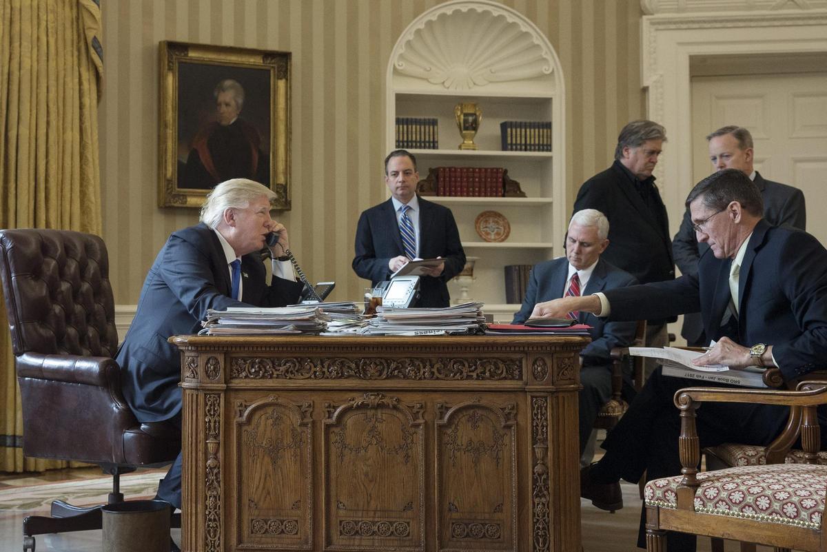 Donald J. Trump habla por teléfono con Vladimir Putin en 2017. Al fondo, de pie, Steve Bannon.