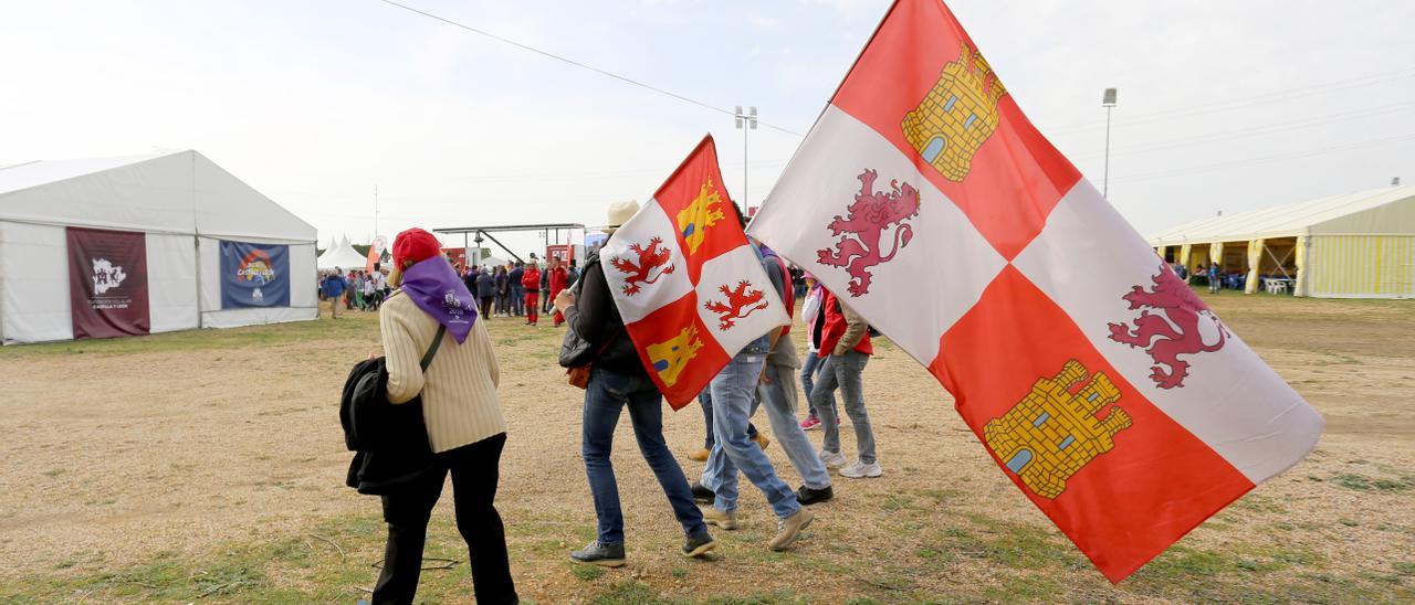 Asistentes a la campa de Villalar portan las banderas de la comunidad.