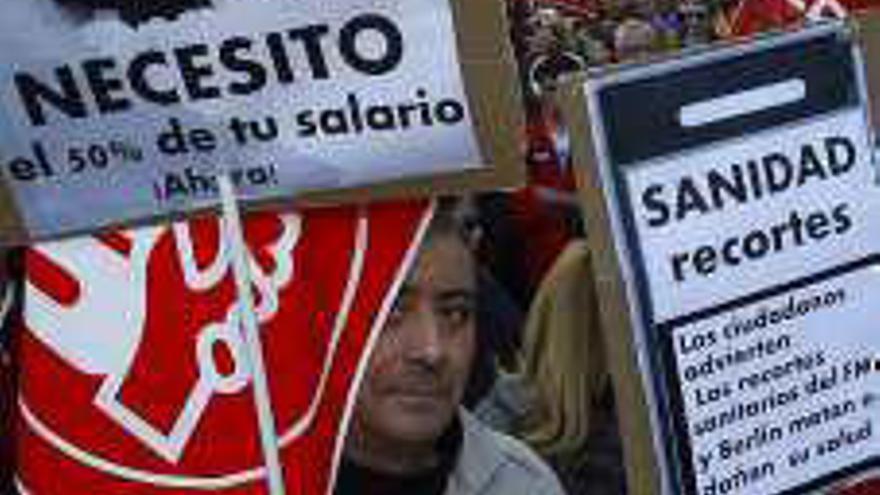 Tres de los carteles y montajes exhibidos por los manifestantes durante la protesta.