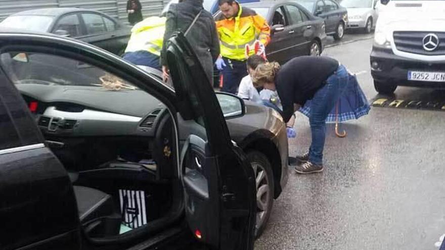 Los servicios sanitarios atendiendo a la mujer que perdió la vida junto al coche que la arrolló.