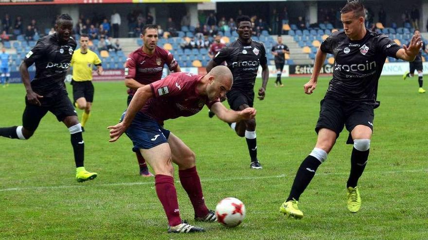 Etxániz tratando de disparar a puerta rodeado de jugadores visitantes en el partido de ayer en Pasarón ante el San Sebastián de los Reyes. // Rafa Vázquez