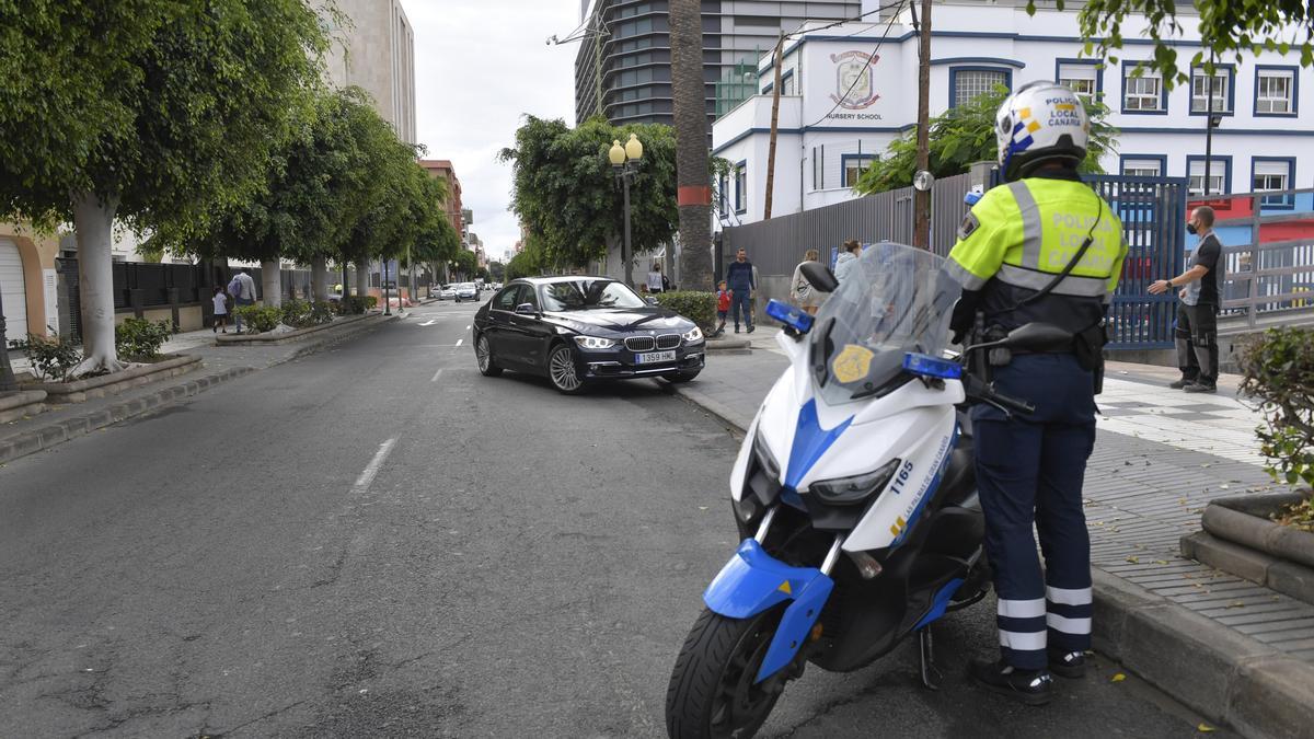 Agente de policía junto al colegio Brains, donde los coches ocupan un carril de circulación a primera hora.