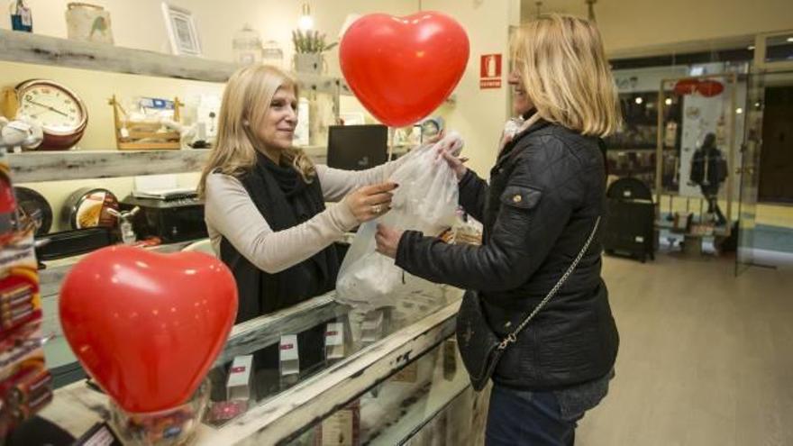 Algunos comercios del centro de Alicante regalan globos en forma de corazón a sus clientes .