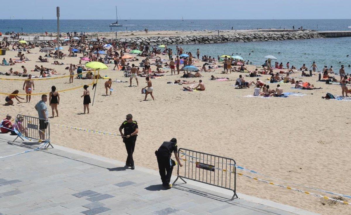 La Guàrdia Urbana delimita con cintas el acceso a la playa del Bogatell, en Barcelona.