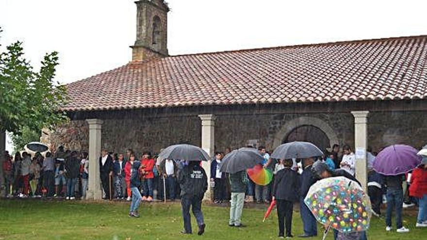 Cientos de personas se reguardaron en la ermita y bajo los paraguas.