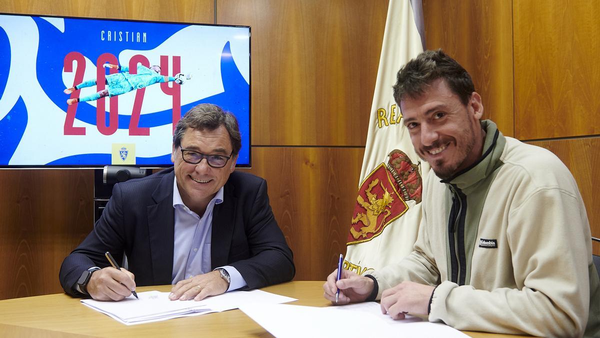 Cristian Álvarez firma la renovación de su contrato junto al director general, Raúl Sanllehí.