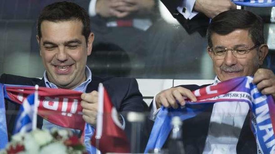 Tsipras y el primer ministro turco, ayer, en el fútbol.