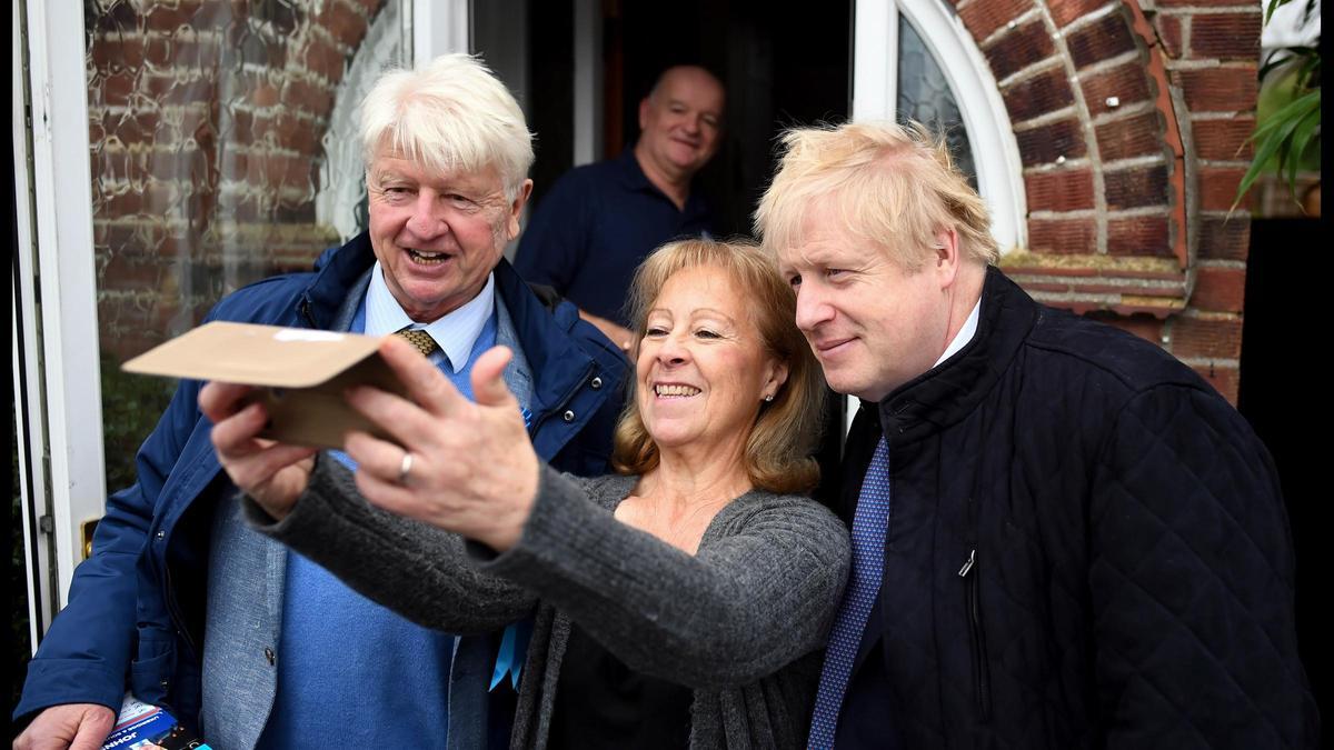 Stanley y Boris Johnson se toman una fotografía con una votante conservadora.