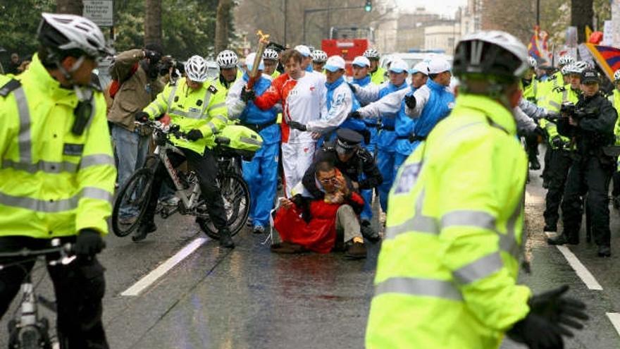 Agentes de seguridad arrestan a uno de los manifestantes que interrumpieran el recorrido de la antorcha olímpica en Londres, Reino Unido.