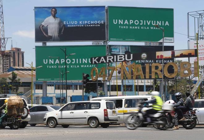 Una valla publicitaria erigida en Nairobi por un proveedor de telefonía móvil local muestra una foto de Eliud Kipchoge, el campeón olímpico y mundial de maratón de Kenia, es fotografiado mientras los automóviles pasan en Nairobi.