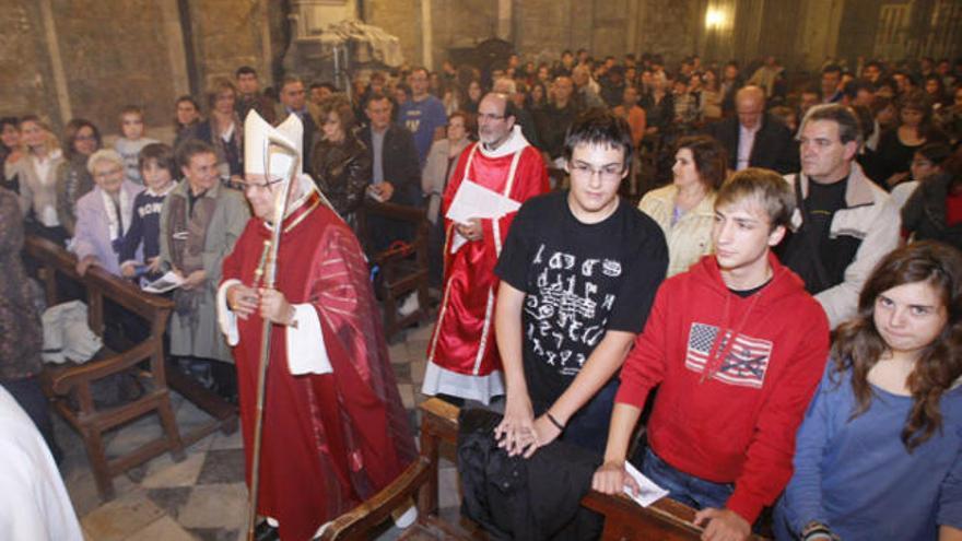 El bisbe de Girona, Francesc Pardo, passa pel passadís central de la capella i, al darrere, el diaca Joan Robé.