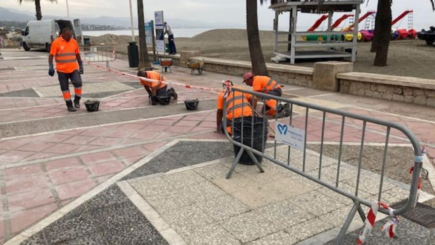 Operarios trabajan en la mejora del paseo marítimo.