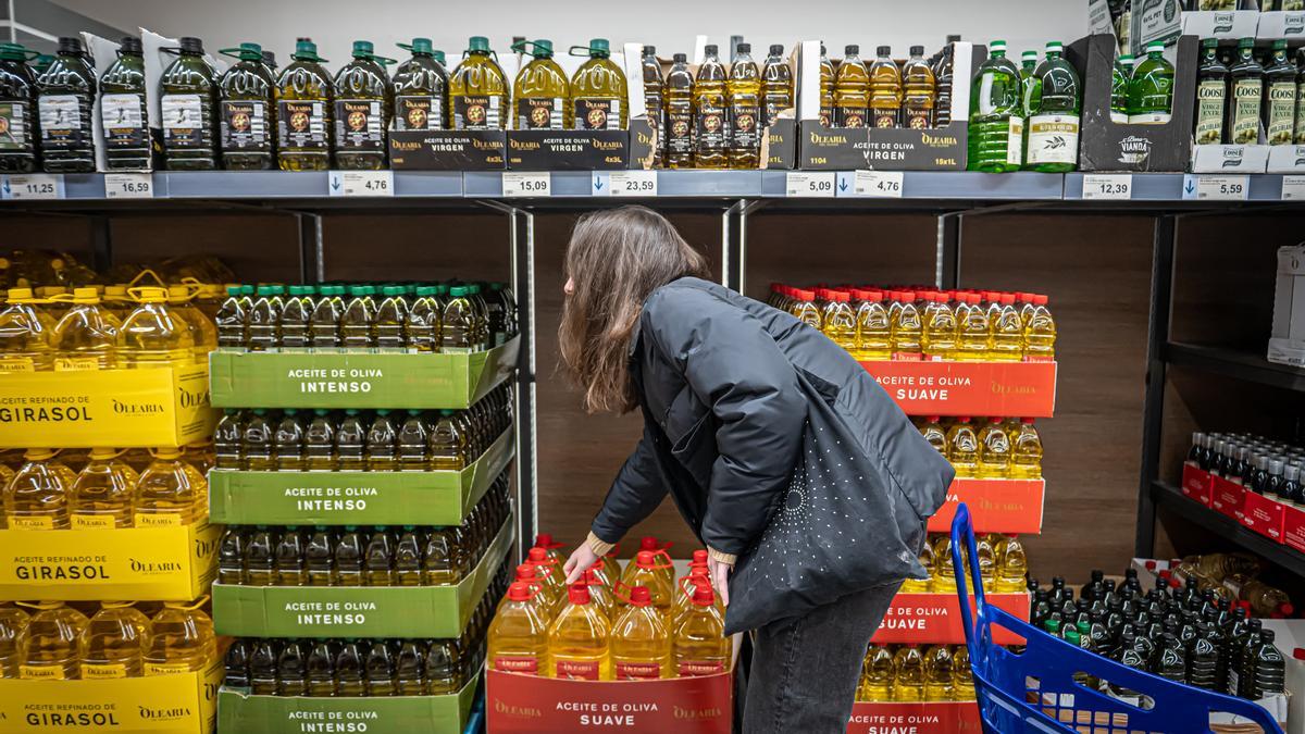 Una mujer compra aceite en un supermercado.