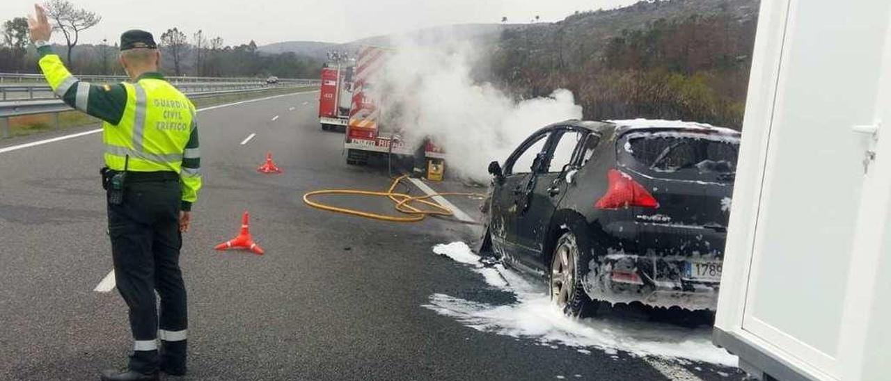 Bomberos y agentes de Tráfico en el lugar del incendio. // FdV