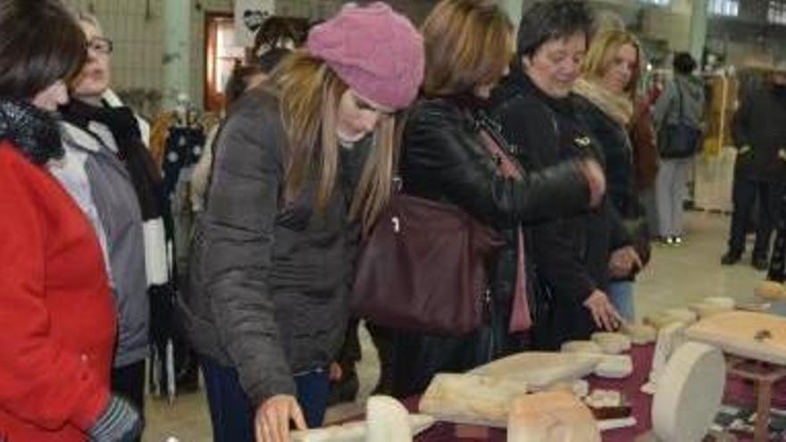 Visitants observen les peces d&#039;un artesà en una parada a l&#039;antiga sala de telers de Cal Metre, ahir