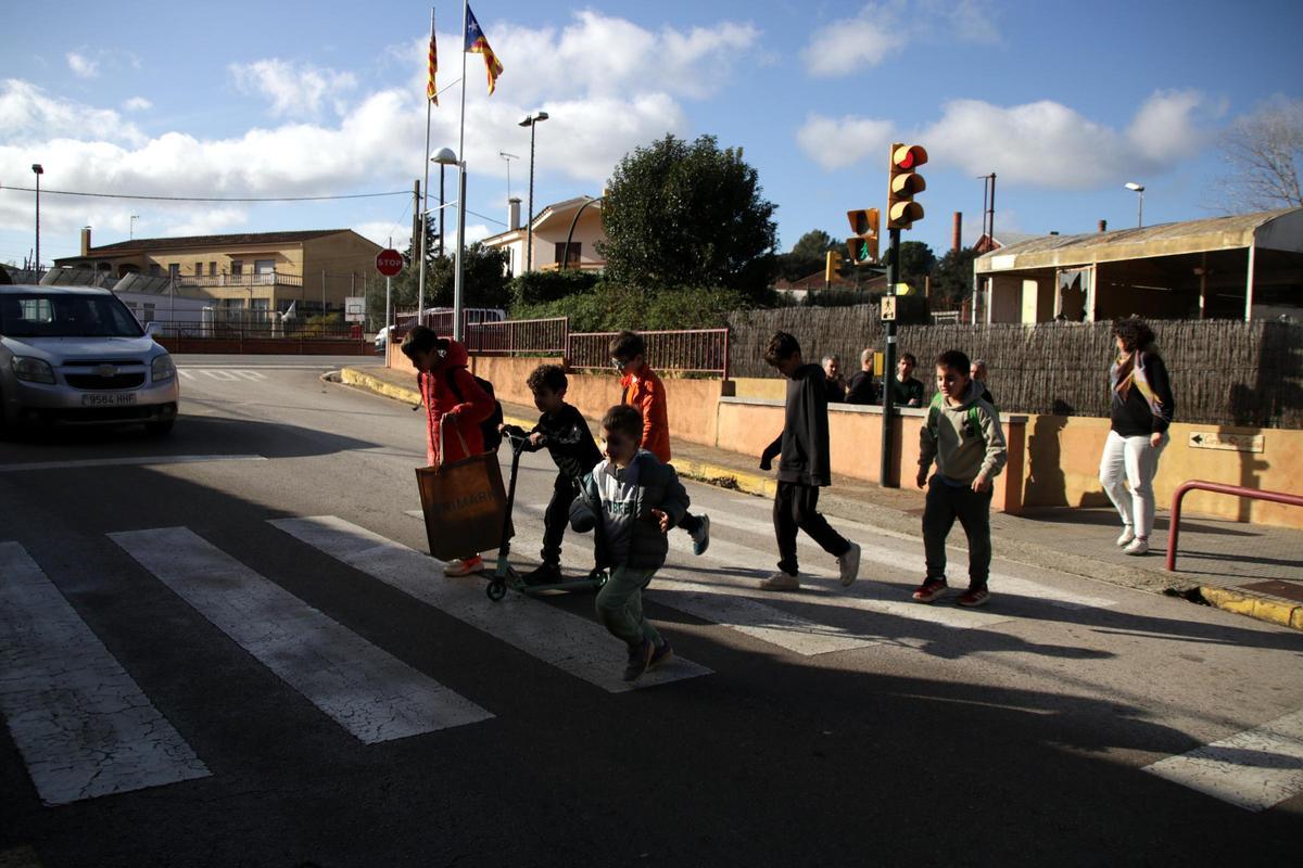 Niños travesando la carretera de Corçà que conecta los dos edificios de la escuela El Rodonell