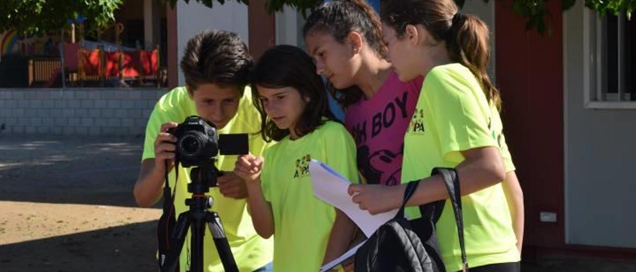 Niños del CEIP El Garbí mirando tras la cámara. Abajo, preparación del rodaje del corto y una imagen de El Garbí TV.