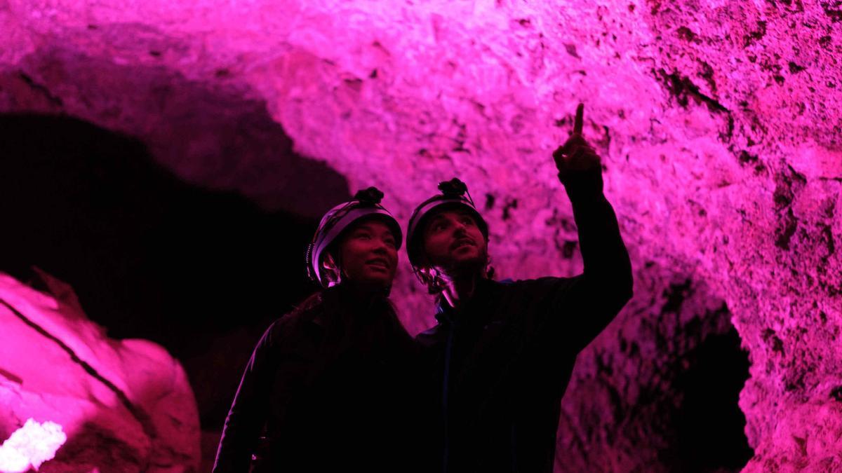 Dos visitantes disfrutan del interior de la Cueva del Viento.