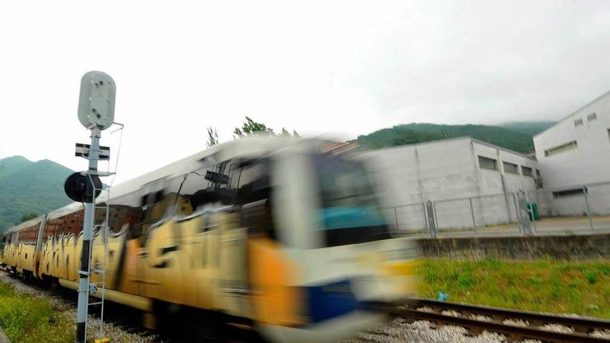 Un tren de Feve, lleno de grafitis, a su paso por Moreda.