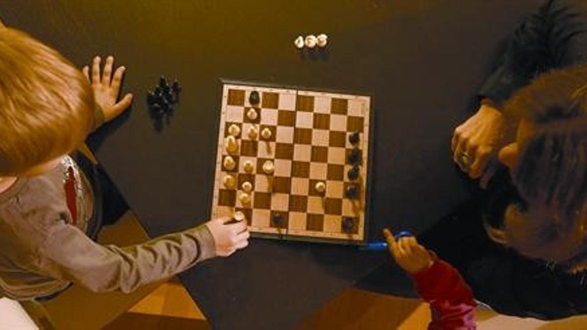 Patrícia juega una partida de ajedrez con su hijo Hèctor, de 5 años.