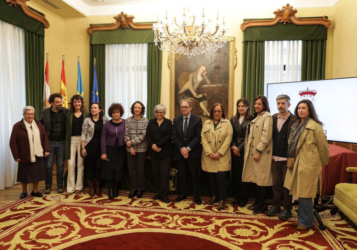 Ana González, en el centro entre Melania Álvarez y Marc Simón, rodeados de personal de la Caixa, la Fundación Municipal de Servicios Sociales, Cuantayá, Siloé y las Religiosas de la Asunción, en el Ayuntamiento. | Juan Plaza