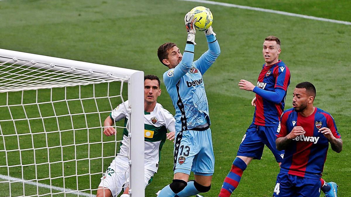 Aitor Fernández ataja la pelota durante el partido ELche-Levante de la pasada temporada.  | EFE/MANUEL LORENZO