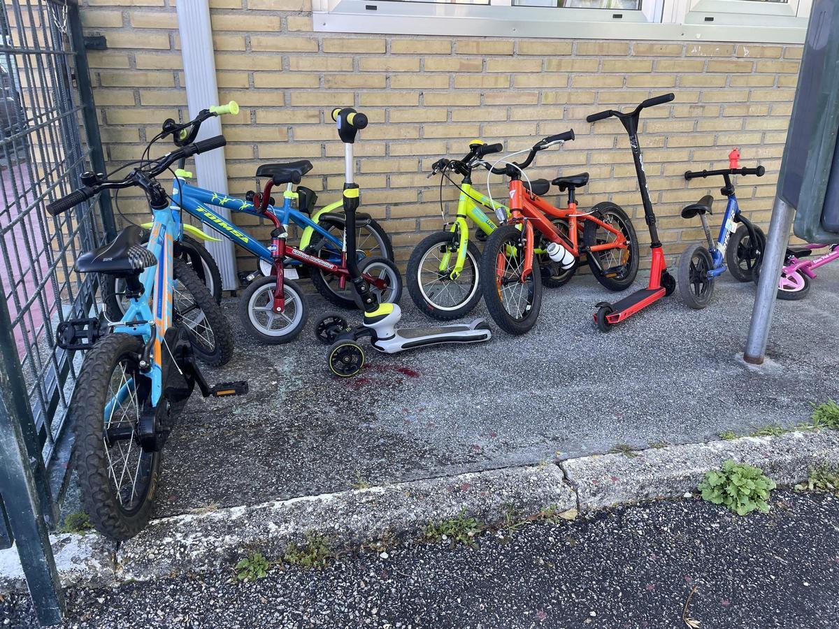 Las bicicletas y los patinetes se acumularon en el patio del colegio.