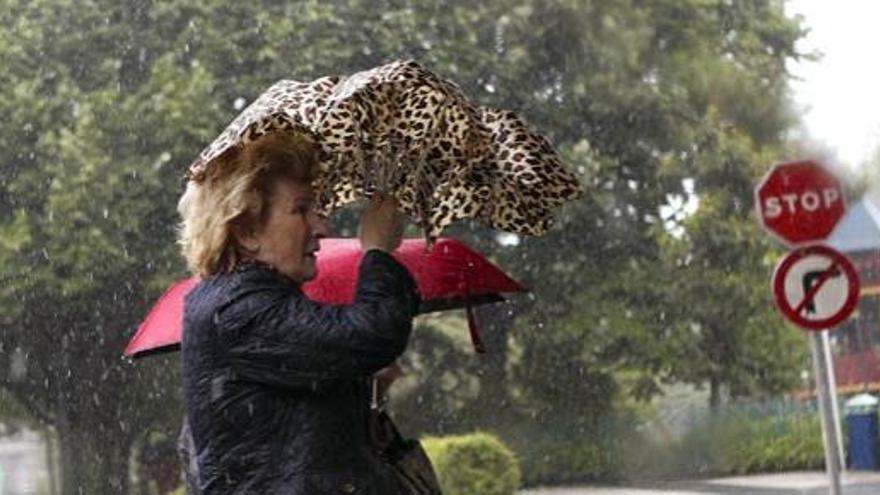 Una mujer camina bajo la lluvia