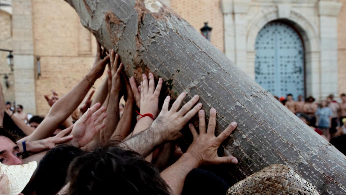 Varias personas empujan al Arbret de Sant Joan.