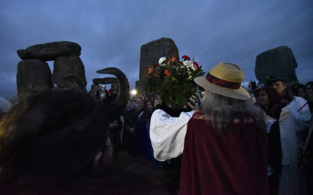 Miles de personas, varias de ellas disfrazadas de druidas, acudieron hoy al monumento de Stonehenge en Inglaterra para ver el amanecer con motivo del solsticio de invierno.