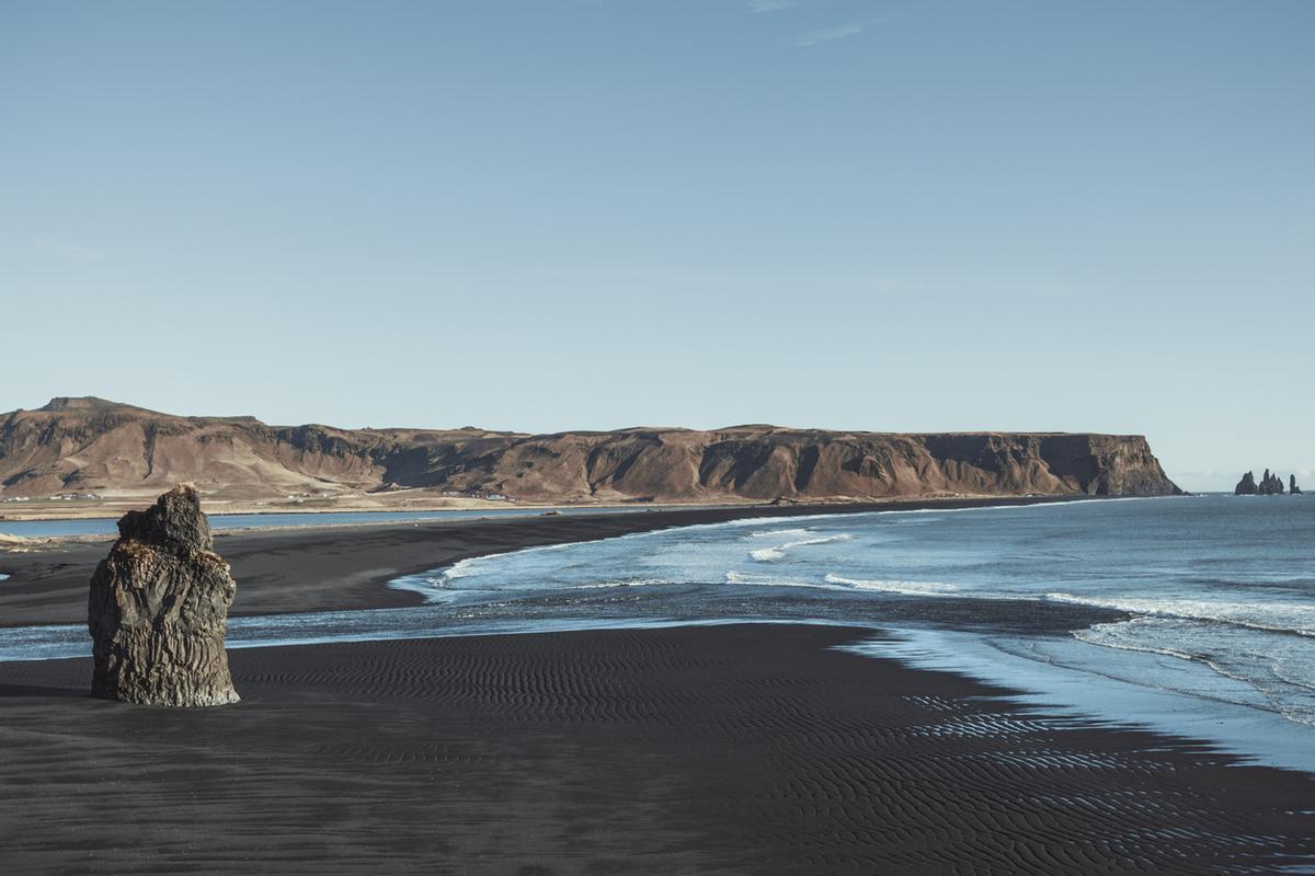 La playa de Reynisfjara, ubicada en la costa sur de Islandia, a 188 km de Reikiavik, es mundialmente famosa por su arena volcánica negra, su cueva marina y sus impresionantes columnas de basalto