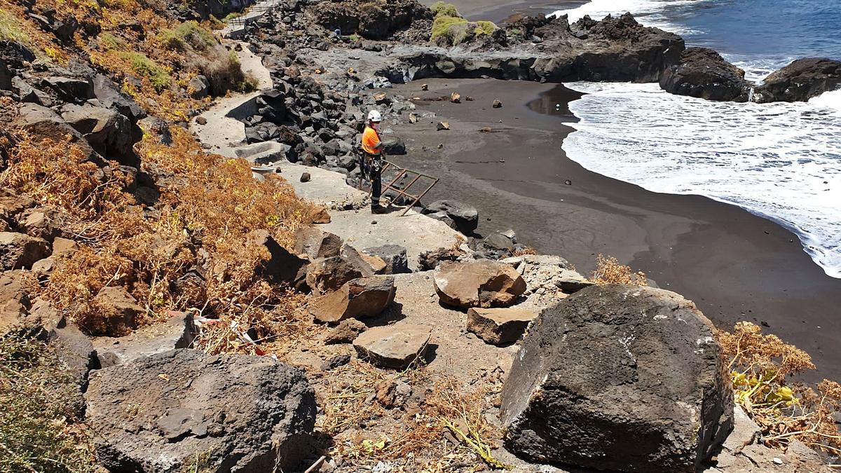 Una empresa especializada trabaja desde el pasado lunes en el saneamiento de las laderas de la playa del Bollullo, donde se han realizado varios desprendimientos controlados de rocas