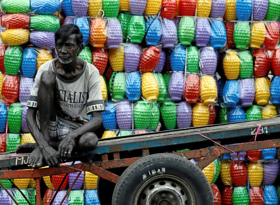 A man rests on his cart after unloading plastic ...