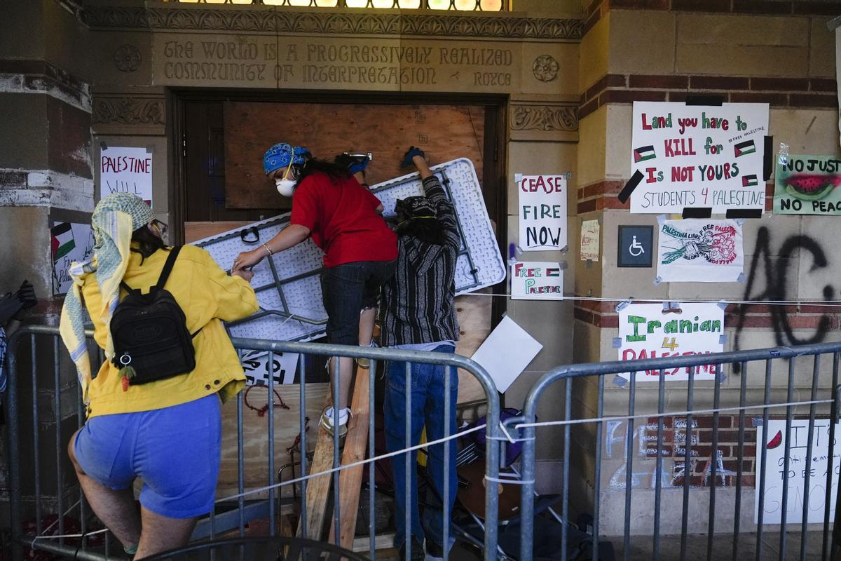 Demonstrators block the entrance to a building on the UCLA campus, after clashes between Pro-Israel and Pro-Palestinian groups, Wednesday, May 1, 2024, in Los Angeles. (AP Photo/Jae C. Hong)
